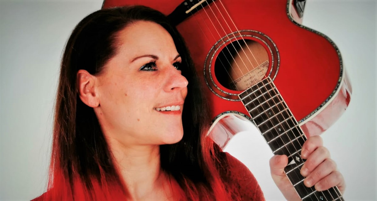 Sängerin TINÆ mit roter Gitarre